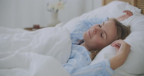 Woman Sleeping in Comfortable Bed. Woman Wakes Up Raise Stretches Hands in Bed Feels Healthy