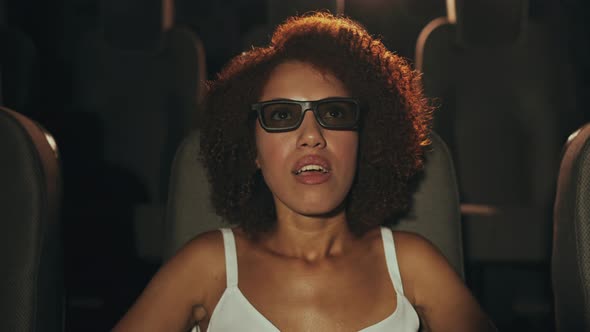 A Young Woman Puts on 3D Glasses to Watch a Movie