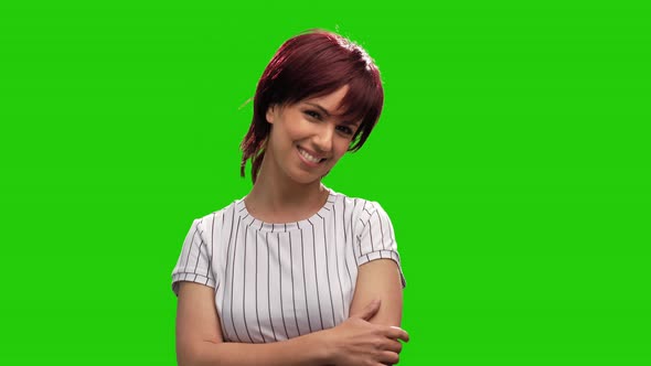 Cute smiling female model on green screen adjusting short hair