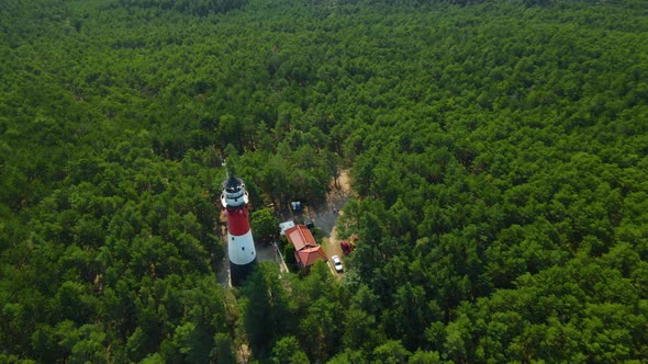 Drone spinning around Stilo Lighthouse and green forest- lighthouse located in Osetnik (formerly Sti