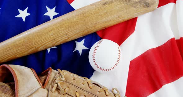 Baseball, baseball bat and baseball gloves on an American flag