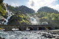 RV traveling on the road Latefossen Waterfall Odda Norway. Latefoss is a powerful, twin waterfall. - PhotoDune Item for Sale