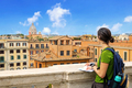 Tourist in Rome, look at the horizon on the city landscape, and consult the city map. - PhotoDune Item for Sale