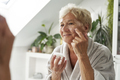 Senior woman applying a face cream - PhotoDune Item for Sale