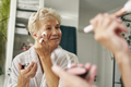 Senior woman doing make up in the bathroom - PhotoDune Item for Sale