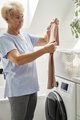 Senior woman about to load a washing machine - PhotoDune Item for Sale