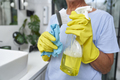 Unrecognizable woman holding cleaning products in washing up glove - PhotoDune Item for Sale