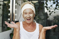 Cheerful senior woman applying cosmetic face mask - PhotoDune Item for Sale