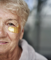 Close up of face of senior caucasian woman with medical eye patch - PhotoDune Item for Sale