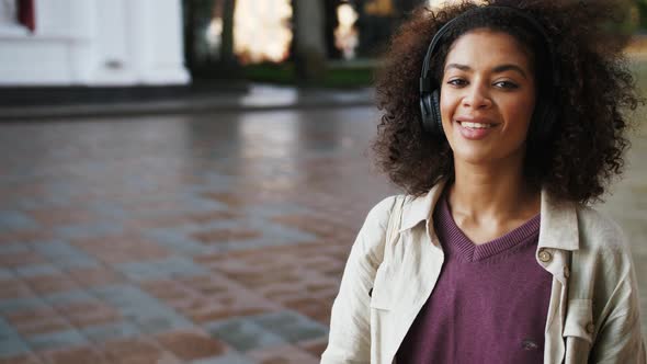 African American Lady in Headphones Linen Shirt and Purple Jersey