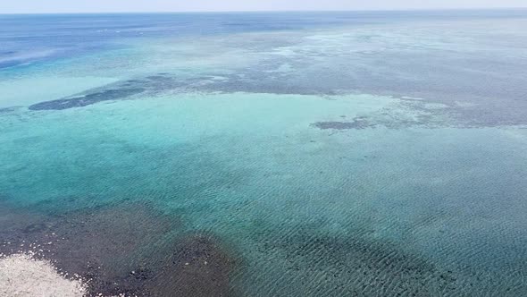 Aerial drone rising over beautiful crystal clear turquoise water and coral reef on coral triangle of