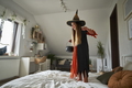 Caucasian elementary age girl jumping on bed wearing witch costume - PhotoDune Item for Sale