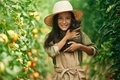 Cute kitten in hands. Little girl is in the garden with tomatoes - PhotoDune Item for Sale