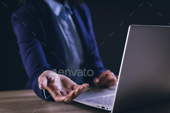 Biracial businesswoman using laptop and holographic display with copy space on black background