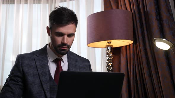 Portrait of Businessman Thinking During Work at Pc