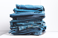 Denim jeans stacked on a white background. Trend clothes, shopping. - PhotoDune Item for Sale