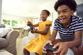 Brother And Sister Sitting On Sofa At Home Playing Video Game Together - PhotoDune Item for Sale