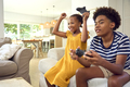 Brother And Sister Sitting On Sofa At Home Playing Video Game Together With Girl Winning - PhotoDune Item for Sale
