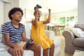 Brother And Sister Sitting On Sofa At Home Playing Video Game Together With Girl Winning - PhotoDune Item for Sale