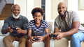 Multi-Generation Male Family Sitting On Sofa At Home Playing Video Game Together - PhotoDune Item for Sale