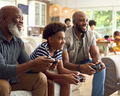Multi-Generation Male Family Sitting On Sofa At Home Playing Video Game Together - PhotoDune Item for Sale