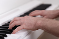 Young man playing on white modern piano\ - PhotoDune Item for Sale