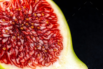 closeup of a green fig in half on a black background