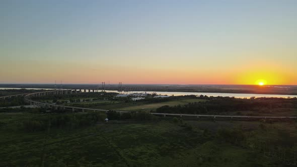 Dolly right flying over green fields and Zarate Brazo Largo road and railway complex cable-stayed br