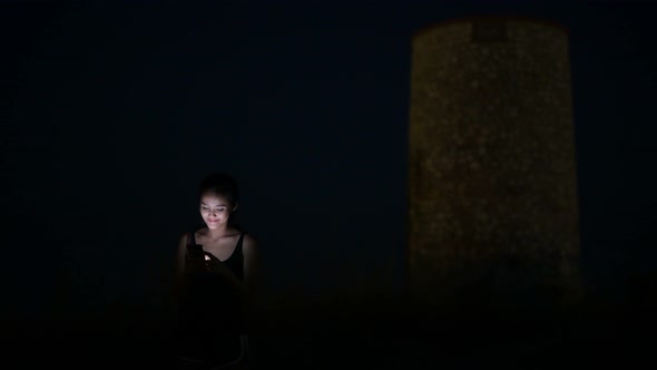 Young Happy Asian Tourist Woman Using Phone On The Hill At Night