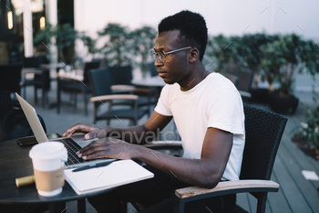 Handsome man in eyewear watching webinar for online learning course