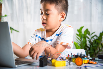 Asian kid boy learns coding and programming with laptop for Arduino robot car
