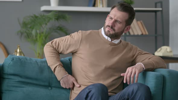 Man Having Back Pain on Sofa