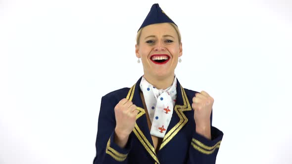 A Young Beautiful Stewardess Celebrates and Smiles at the Camera - White Screen Studio