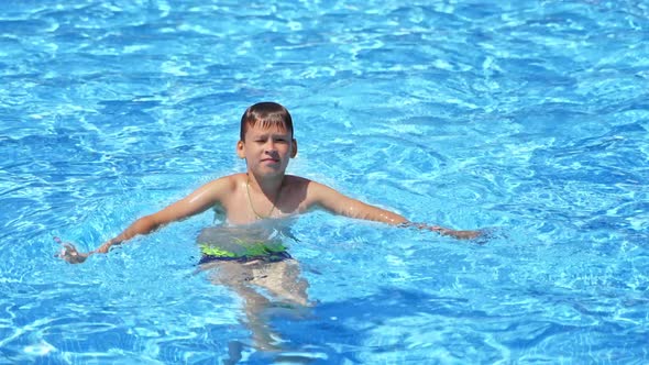 Boy at swimming pool. Happy children in swimming pool having fun on summer vacation