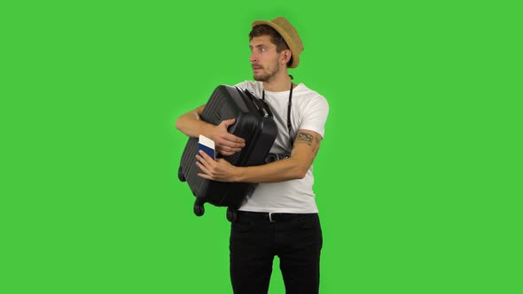 Tourist with Suitcase in Hand, Passport and Ticket Is Looking Around. Green Screen