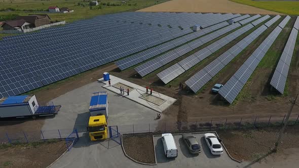 Aerial View of a Massive Solar Power Station and a Truck Driving