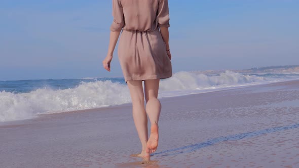 Woman Walking on Sand Beach with Ocean Waves