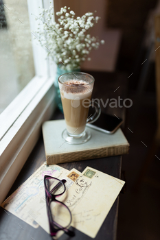 Glass of mocha coffee on a book on a windowsill