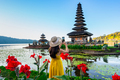 Young woman tourist relaxing and enjoying the beautiful view at Ulun Danu Beratan temple in Bali - PhotoDune Item for Sale