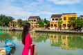 Young female tourist in Vietnamese traditional dress walking at Hoi An Ancient town in Vietnam - PhotoDune Item for Sale
