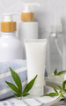 White blank cream tube near green cannabis leaves close up, CBD cosmetic mockup - PhotoDune Item for Sale