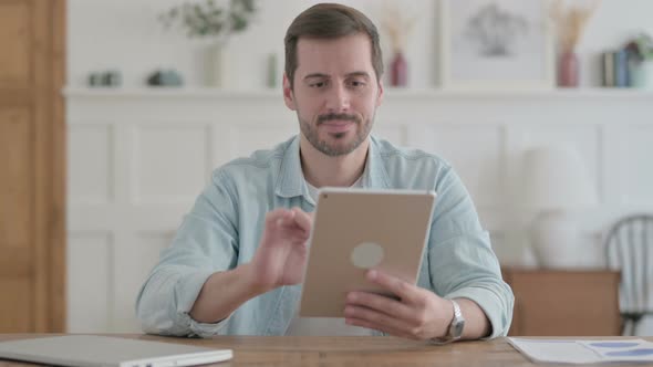 Young Man Doing Video Call on Tablet in Office