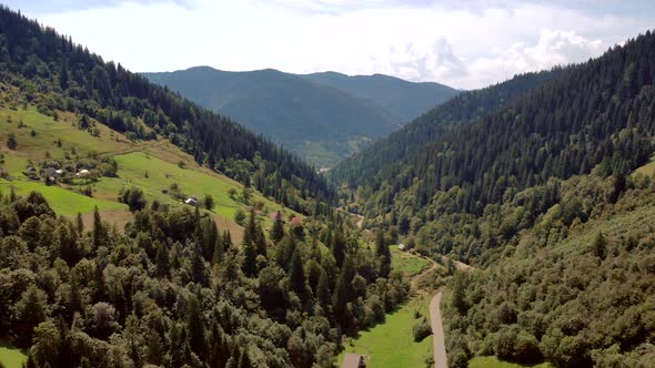 Mountain Peaks with Forests on Cloudy Sky Background