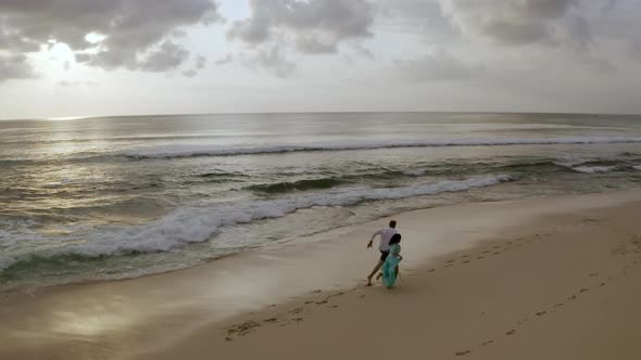 Happy Young Couple Running on Beach Enjoying Freedom and Nature