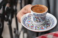 hand holding a a cup of turkish coffee on table  - PhotoDune Item for Sale