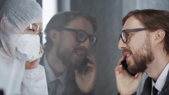 Man Communicates on a Mobile Phone with a Asian Woman Through Glass, Put Their Hands To the Glass, a