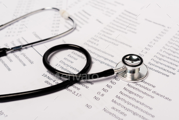 Close up view of stethoscope on paper lists with hormones isolated on white