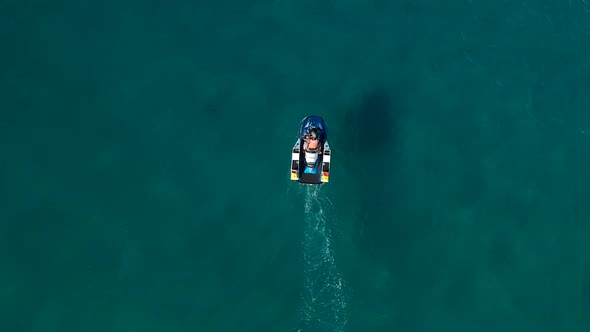 Aerial view of a jet ski rider accelerating from a standstill position