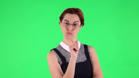 Portrait of Funny Girl in Round Glasses Seductively Smiling, Gesture Threatens By Shaking Her Index