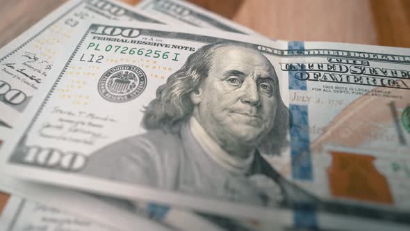 100 dollar bills falling on top of each other extreme close-up shot